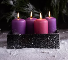 Advent candles lit on a snowy backdrop